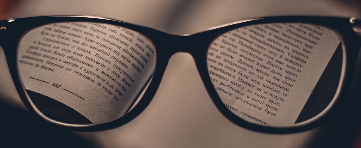 Communicate with a voice actor: image of a pair of glasses focusing on a page