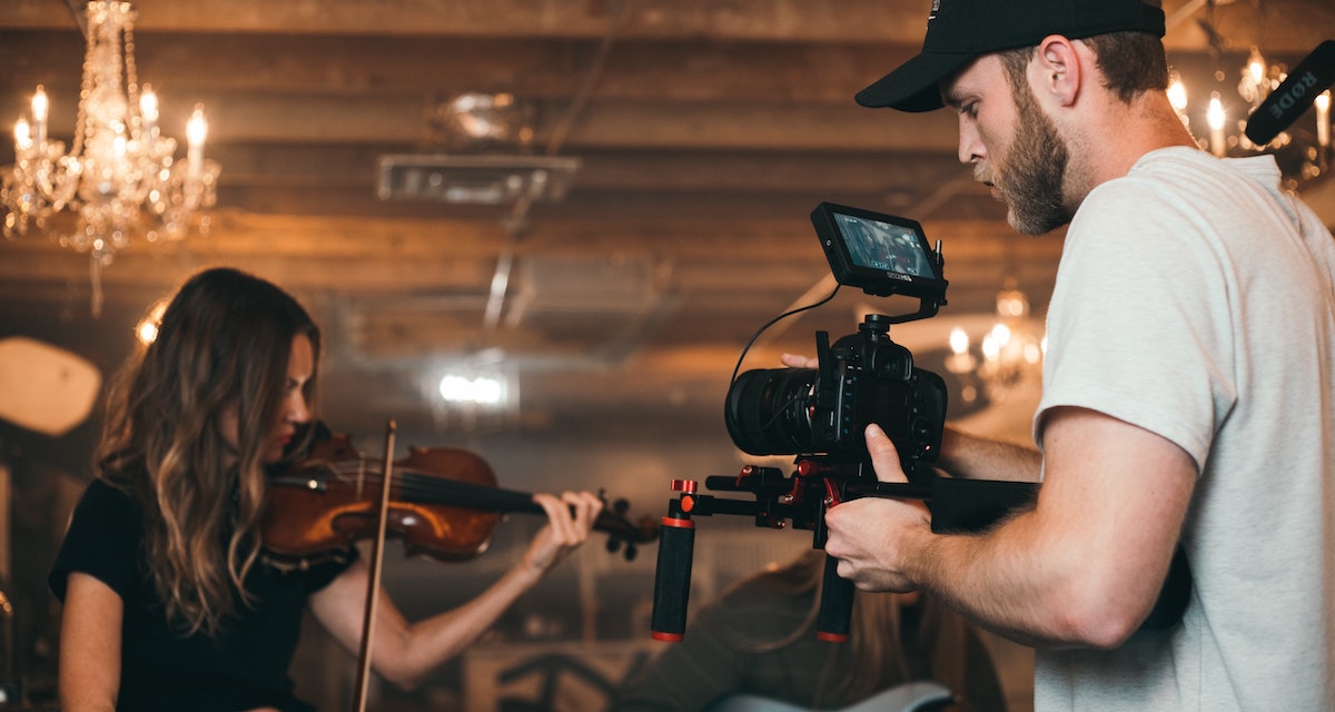 music and VoiceOver: image of a cameraman filming a woman playing the violin