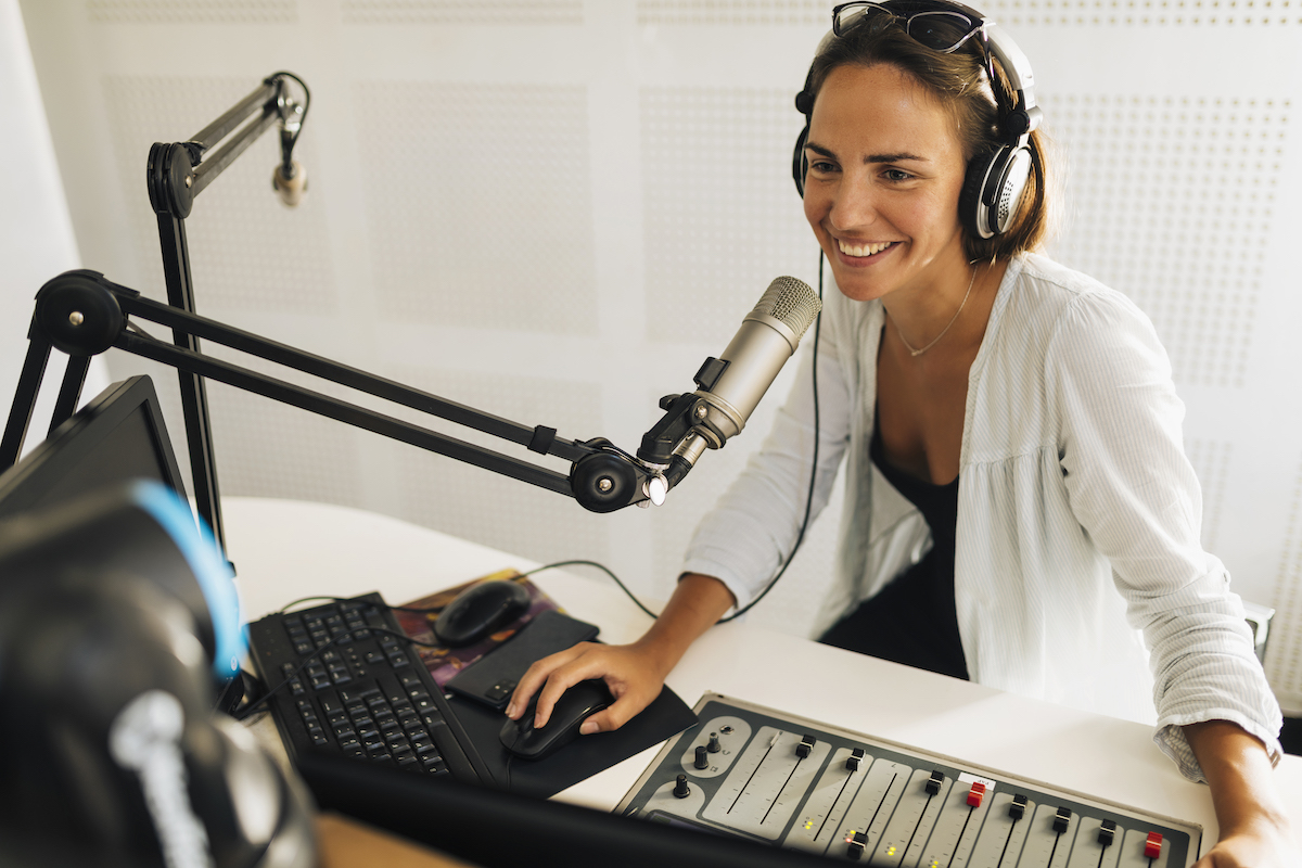 Market your podcast: image of female podcaster smiling