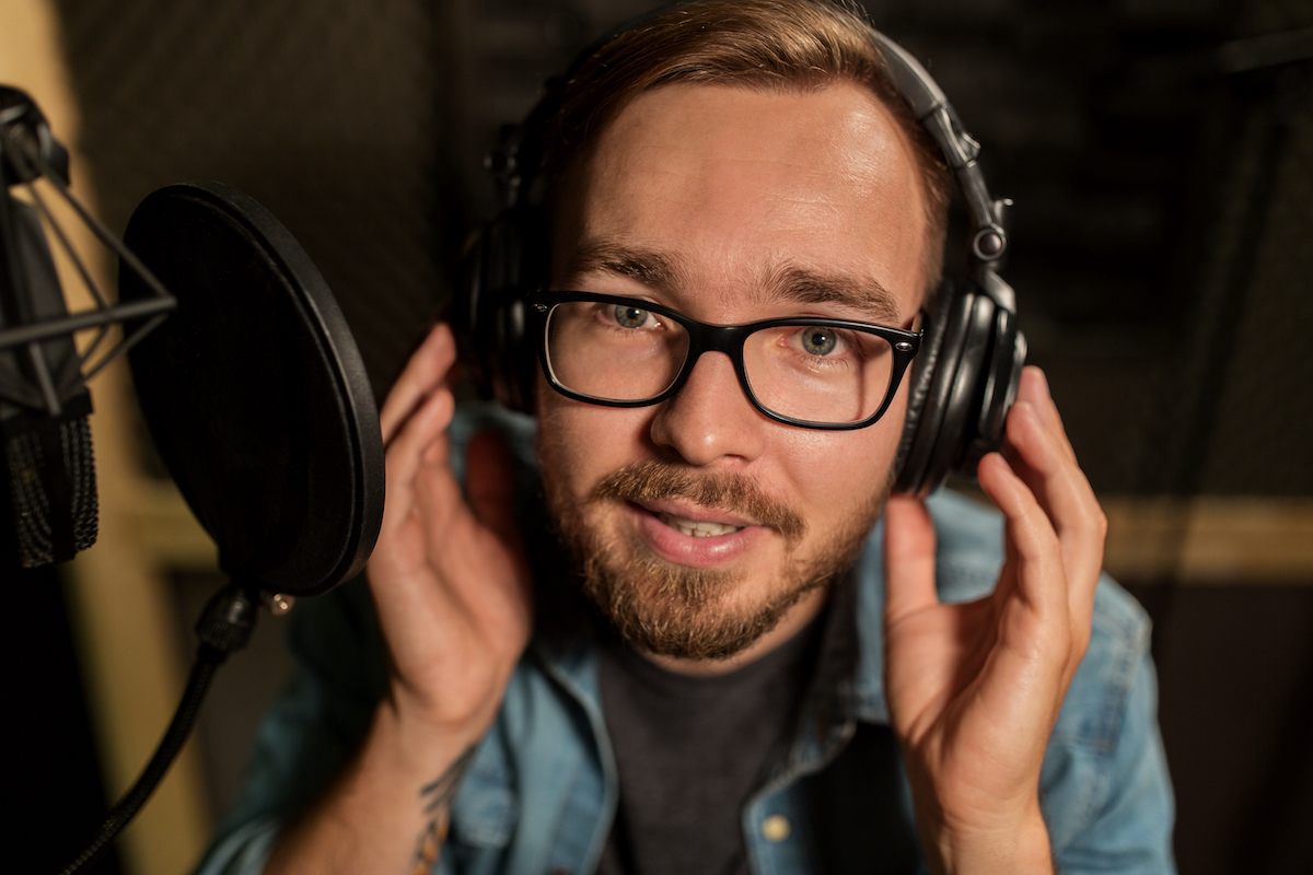 voice over talent for hire: Young voice actor inside a recording booth