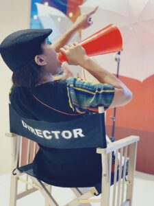 Voice talent: woman director sitting in a director's chair with a loud hailer